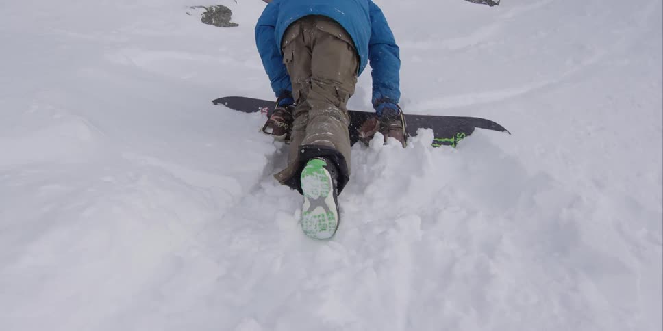 A snowboarder making his way through the snow