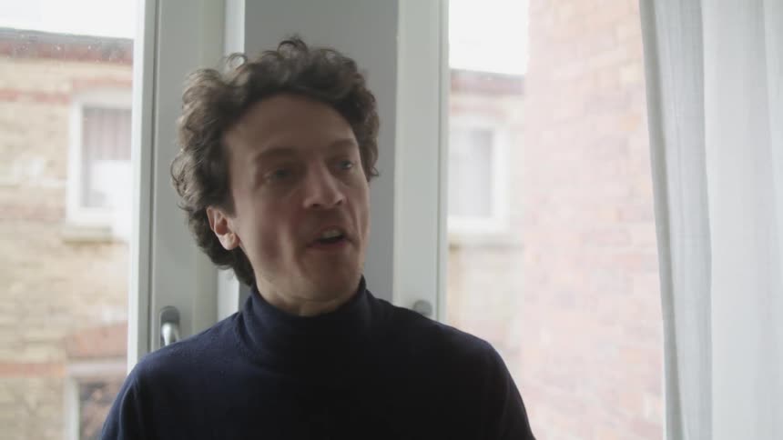A man that is standing in front of a window and yelling
