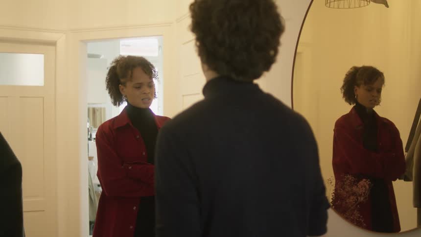 Young couple having an argument in front of a mirror in a room at home