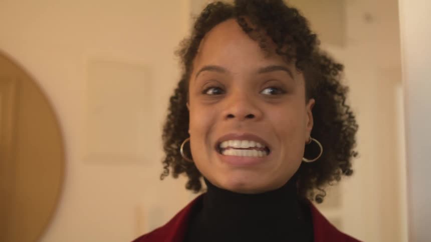 An upset woman standing indoors arguing with a person out of frame