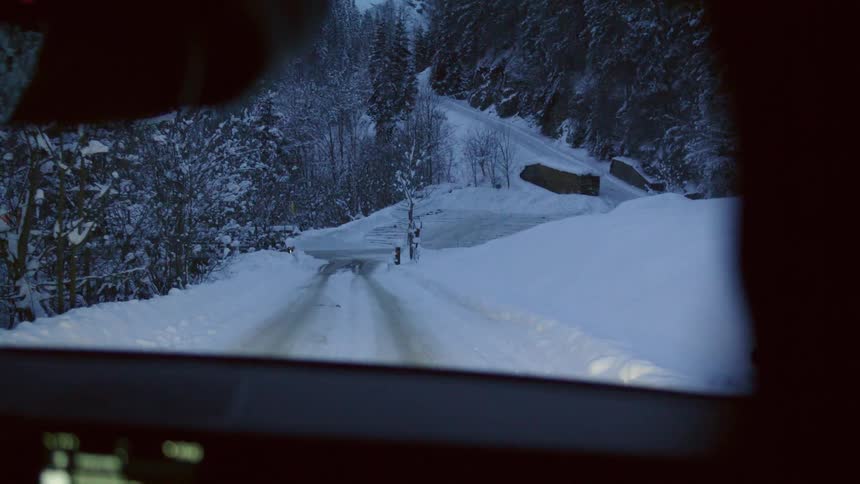 Driving down a road with a lot of snow on it