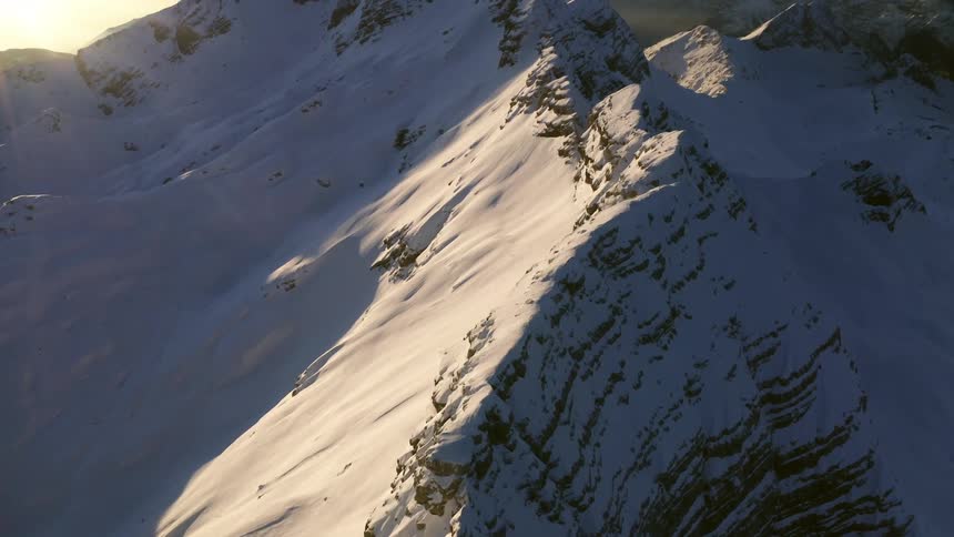 Sunlight shines on a snow covered mountain ridge