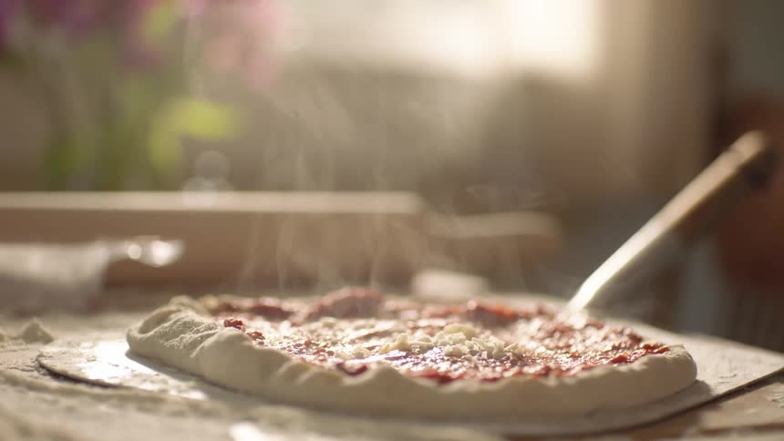 A man is preparing pizza at his home
