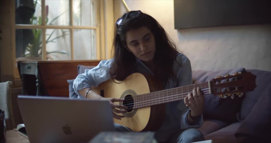 A woman playing an acoustic guitar
