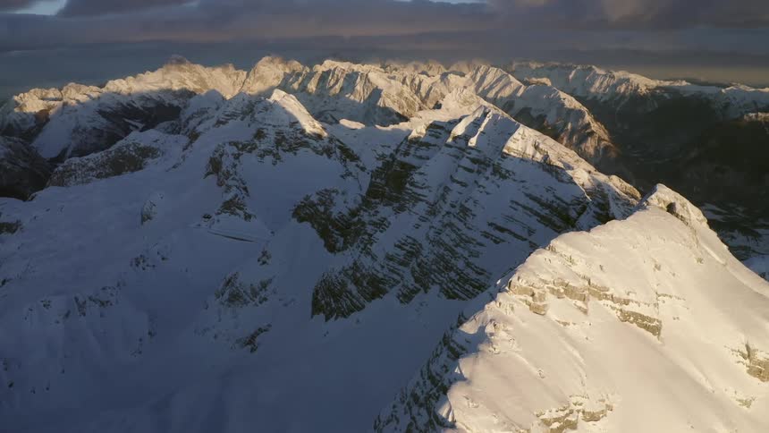 Aerial view of a large mountain range summit covered in snow