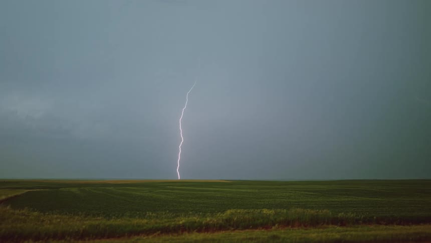 A single enormous bolt of lightning descend from the sky during a powerful storm