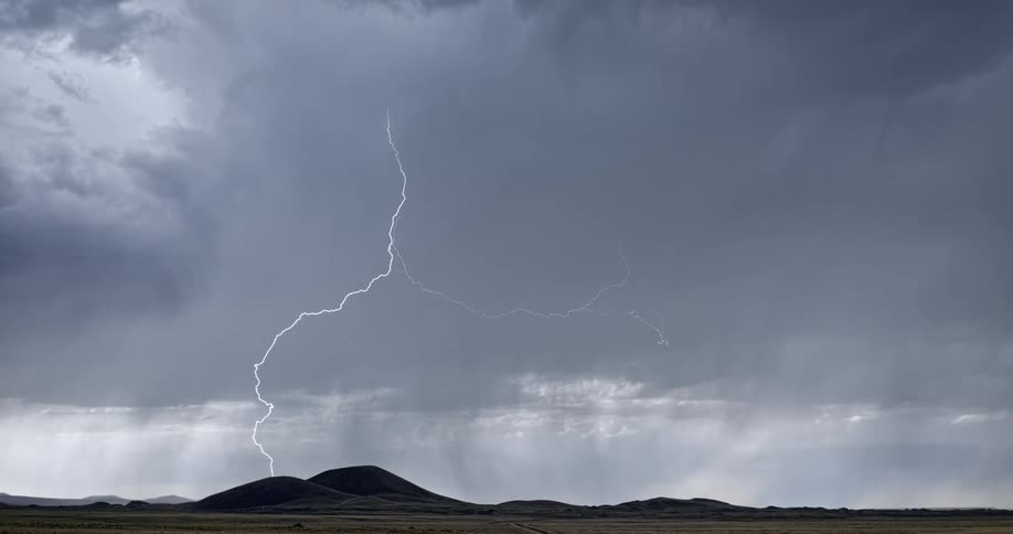 Lightning bolts flash and branch out over mountains