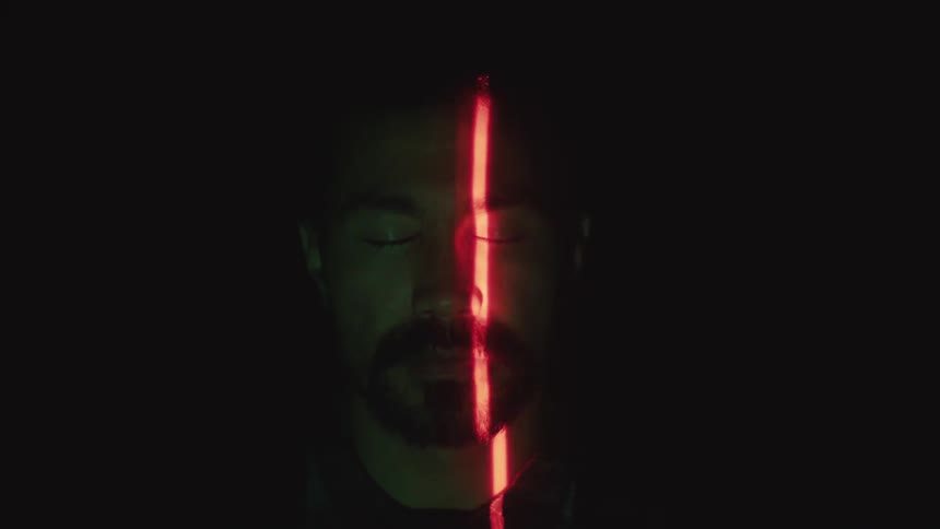 A man closes his eyes while a red beam scans his face and the word positive appears on his forehead