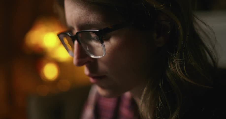 A woman sitting at home in the evening