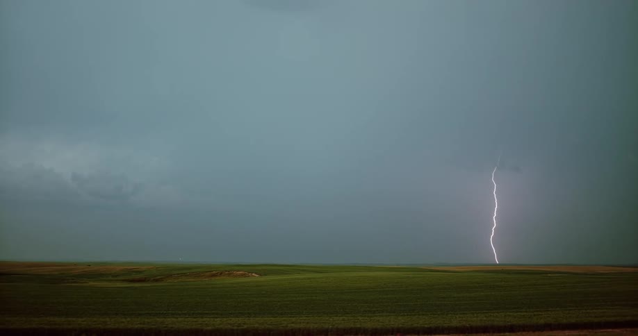 Lightning bolt flashes in the sky and hits the ground