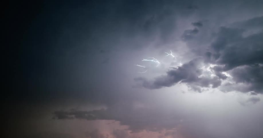 Enormous bolts of lightning are emitted from dark storm clouds and streak across the sky
