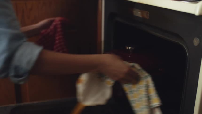 A person removes a pot from the oven