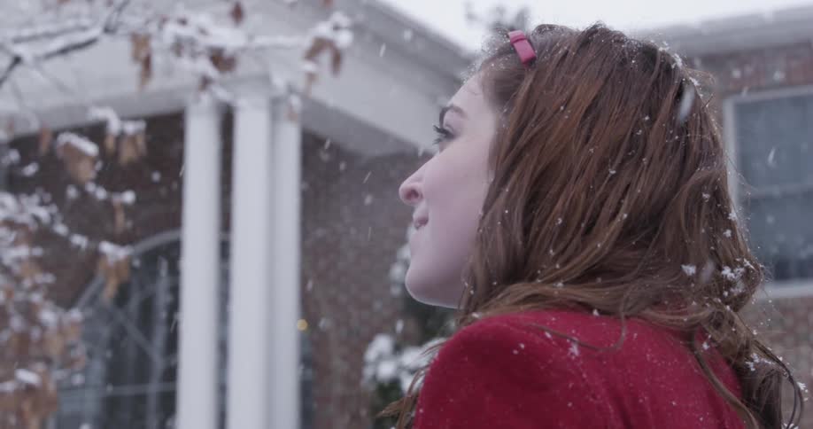 A woman in red stands outside in the snow