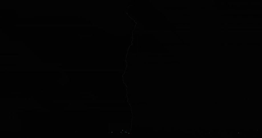 Lightning bolts flash and branch out in a dark sky