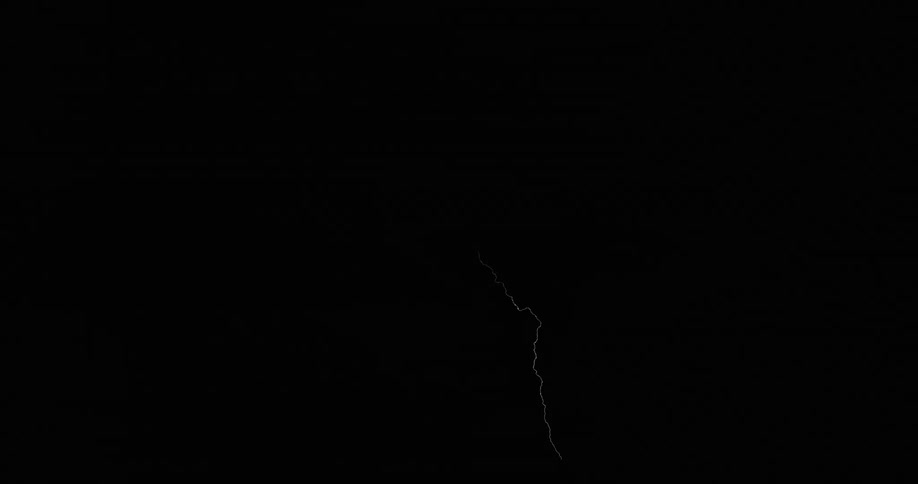 Lightning flashing in a dark night sky during a thunderstorm