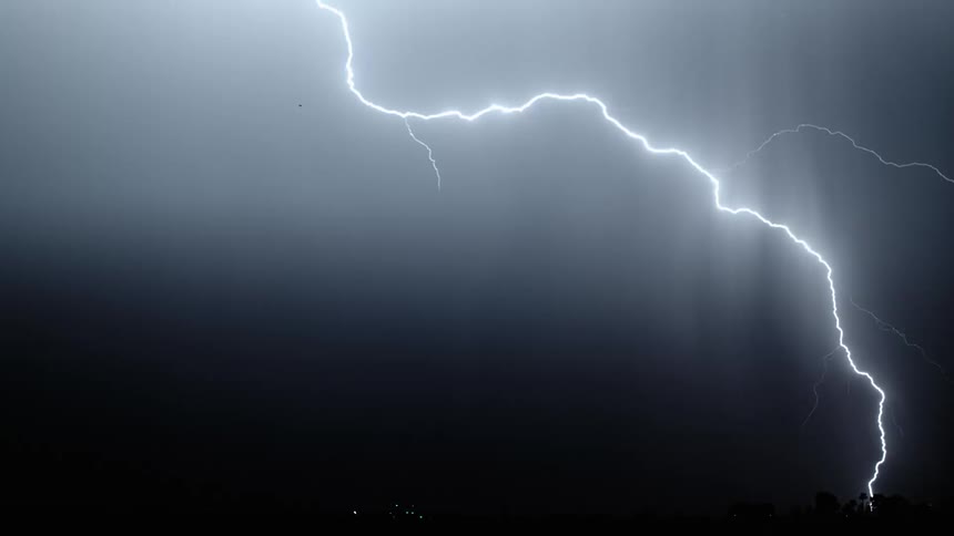 Lightning flashing and branching out in a dark sky