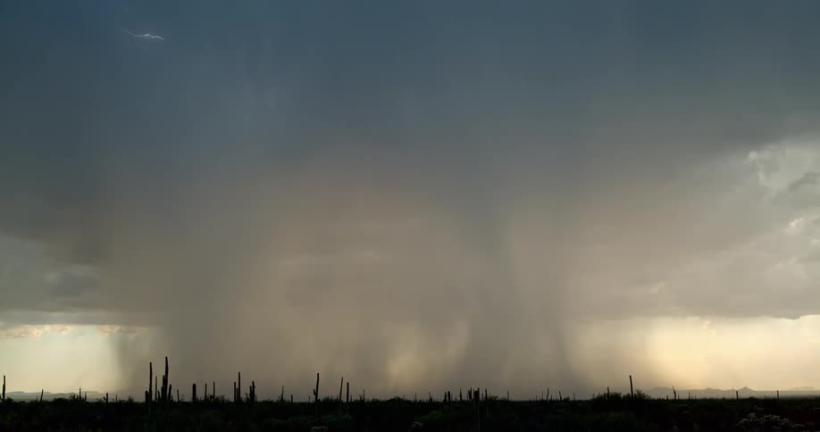 Lightning bolt from dark storm cloud hits the ground as a storm moves in