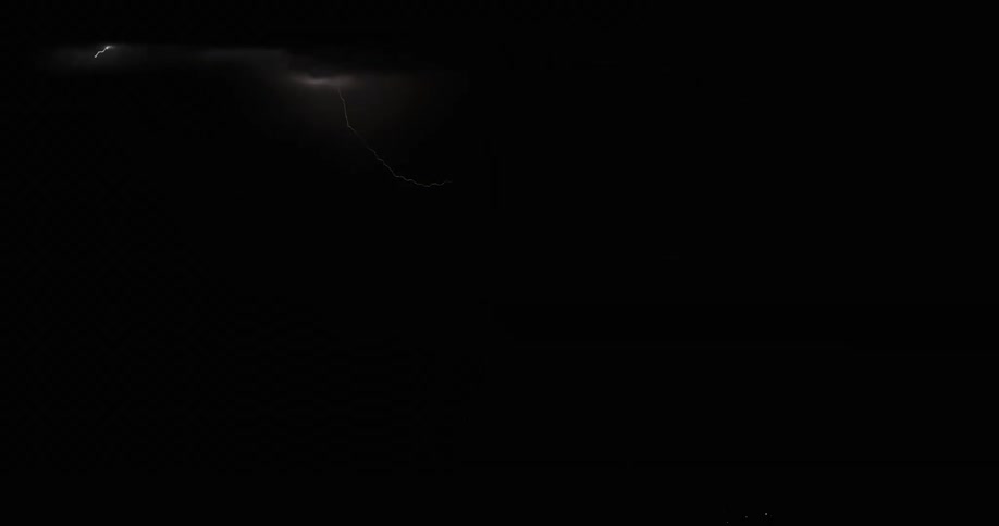 Lightning flashing in a dark sky during a rainstorm