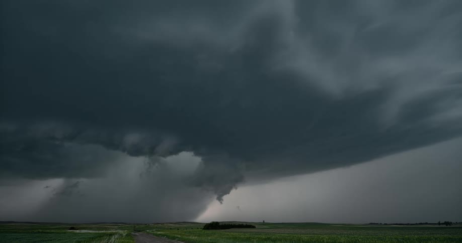 Lightning flashing from dark storm clouds over rural area