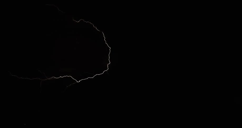 Lightning bolts flash and branch out in a dark sky