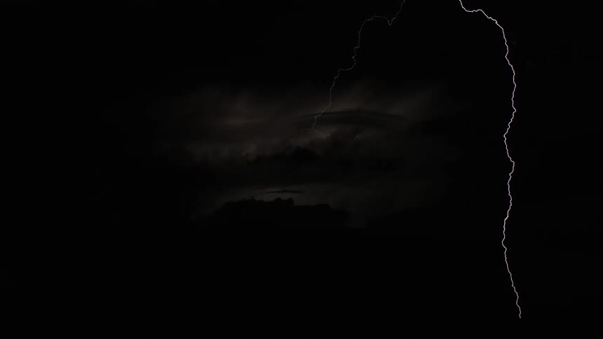 Lightning streaking arcs flashing and striking the ground at night