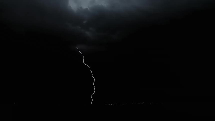 A storm with lightning over a landscape with the sky and clouds in the background