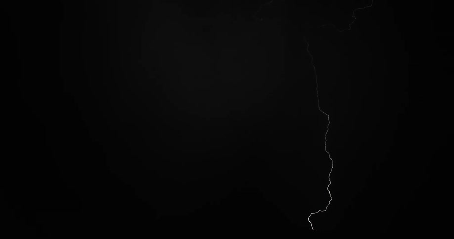 Lightning strikes in zig zag lines across the sky at nighttime in a thunderstorm
