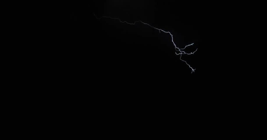 Bolts of lightning spread throughout the night sky over a mountain during a thunderstorm