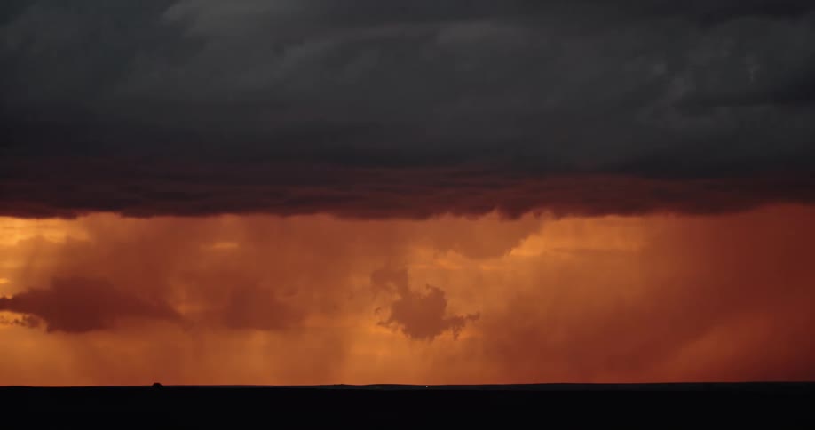 Lightning streaking arcs flashing across yellow storm clouds hitting the ground over a field