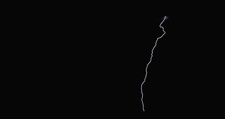 Lightning scatters around and strikes down from a storm cloud in a dark sky at nighttime