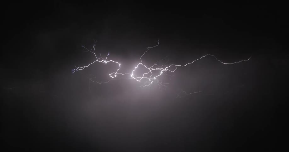 Lightning streaking arcs flashing across black storm clouds at night