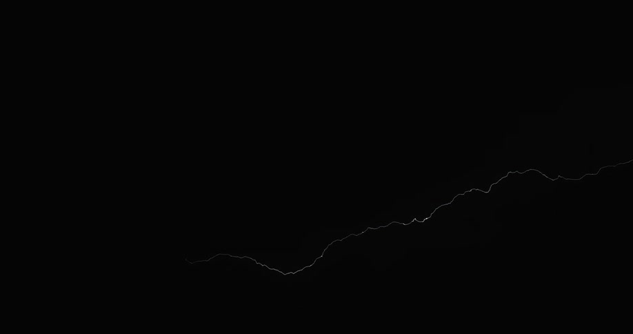 Several large bolts of lightning streak across a dark sky during a powerful thunderstorm