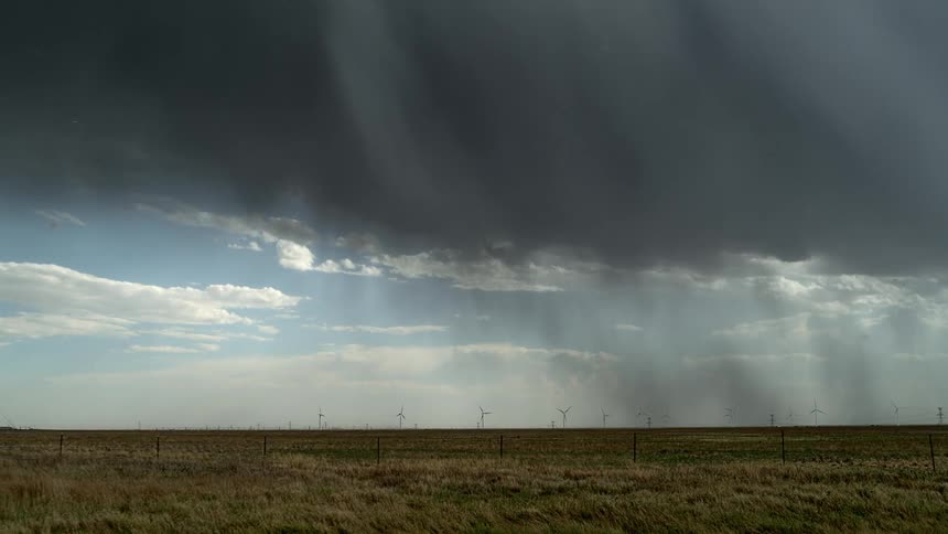 Driving by the countryside as a lighting bolt strikes from a dark cloud