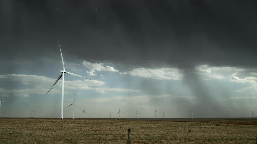 A lightning storm moves through a turbine valley