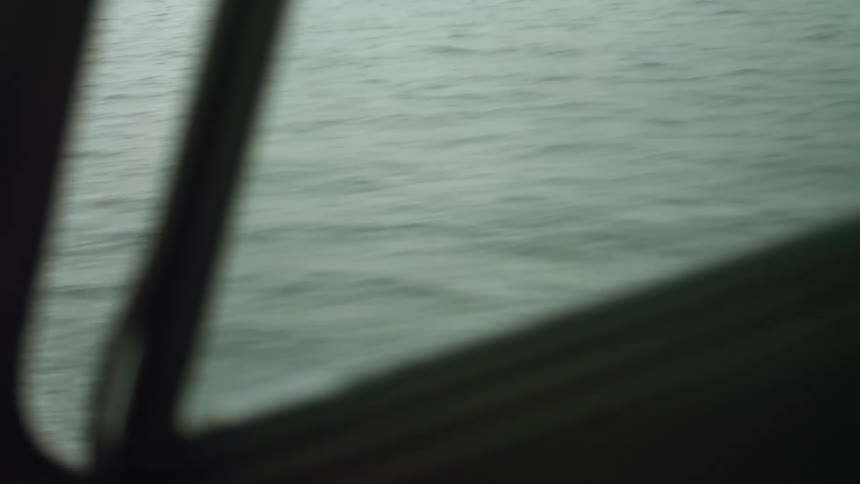 A view out a window of a boat on a lake