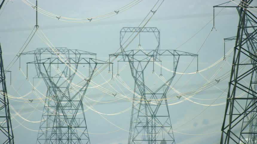 High tension and high energy electrical transmission lines are seen in this dynamic shot as the camera dynamically passes by the infrastructure network