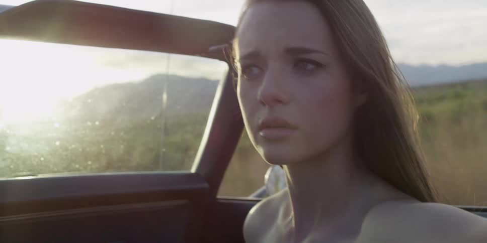 A woman in a car riding down the road looking around