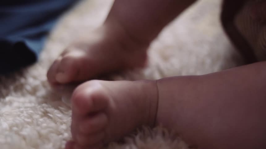 Baby chunky feet wiggling on a white furry rug