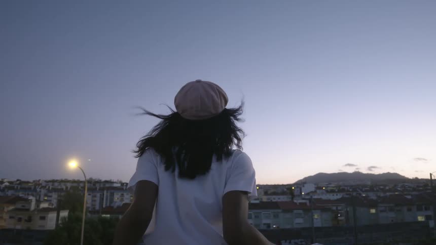 A woman is watching the town from the roof