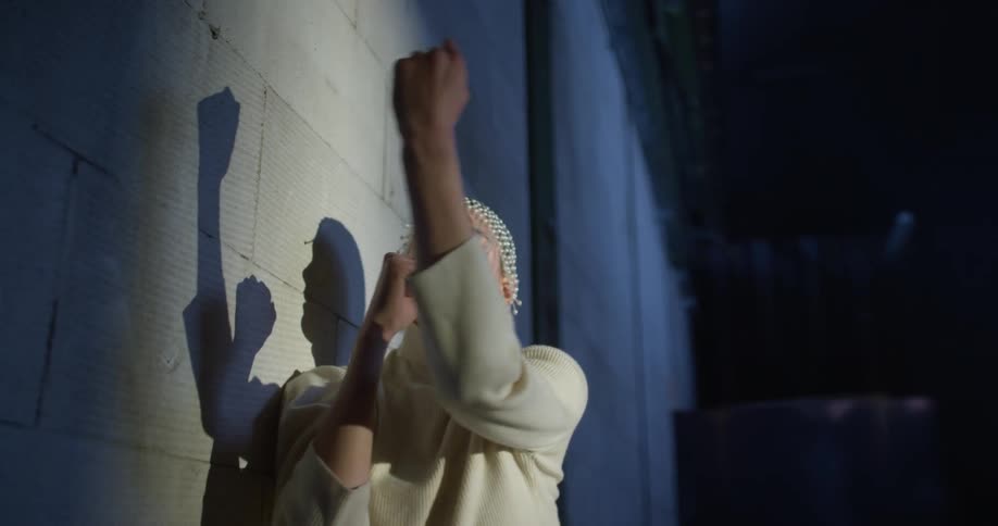 A person standing next to a wall on a stage