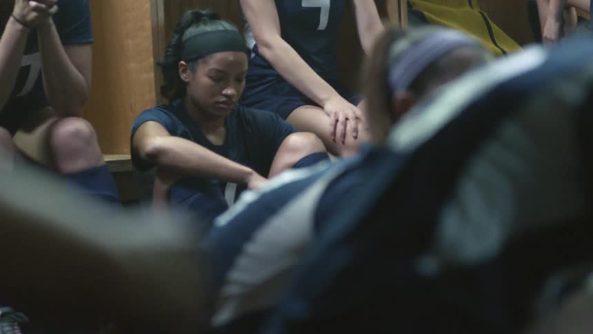 A female sports team rests in their locker room