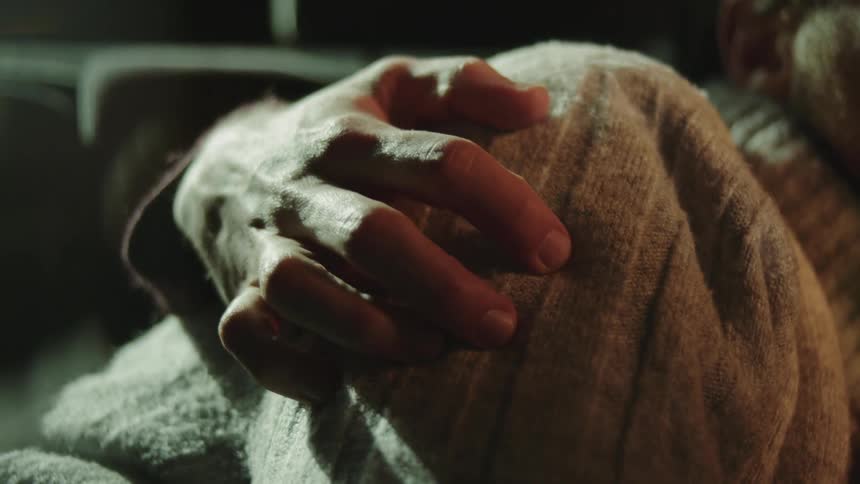 A man lies next to his boyfriend and rubs his shoulder