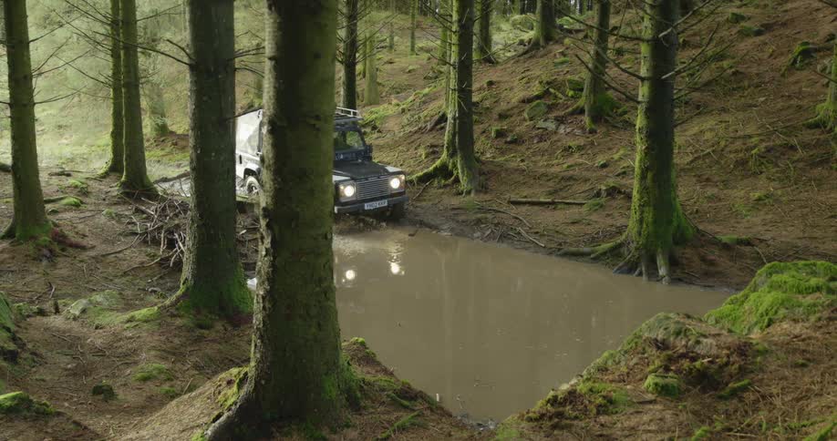 All terrain vehicle driving over a flooded path in the forest