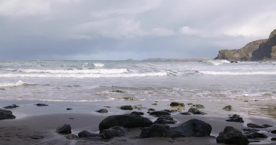 Waves crash against the shore with oceanside cliffs