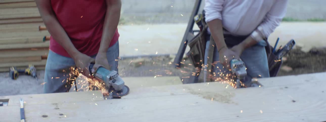 Sparks fly from men using power grinders