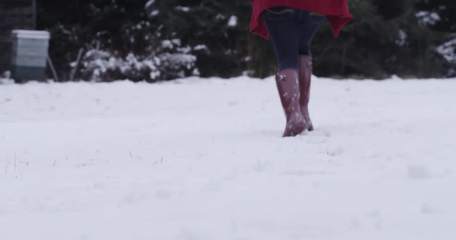 A woman in a red coat runs in the snow