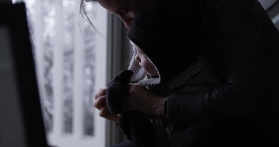 A woman is putting gloves on a child's hands