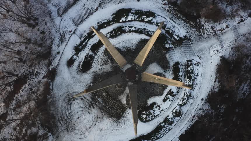 Aerial view of a star shaped monument on the top of a snow covered hill