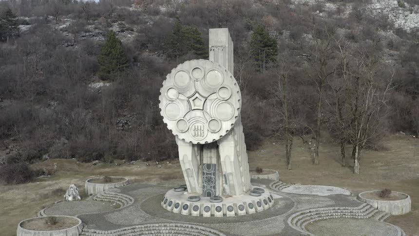 A large stone circular shaped piece of environment art outdoors in a forest at daytime