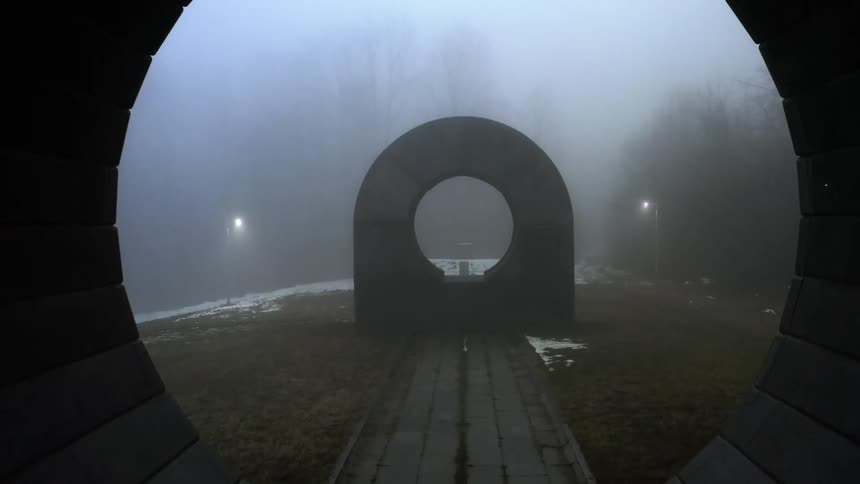Geometric hollow concrete sculptures standing in the mist on a park